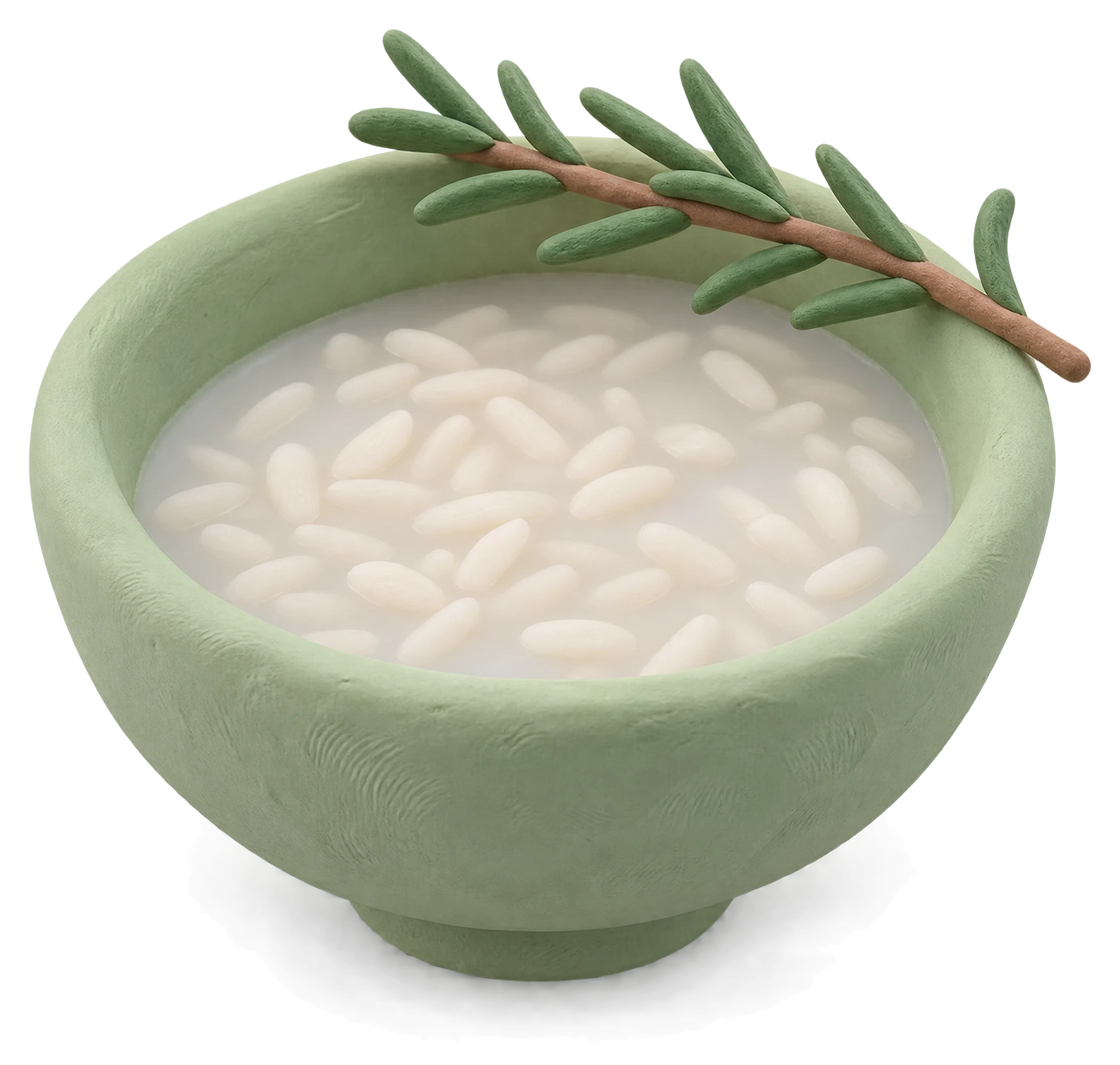 A green clay bowl of rice in cloudy water, a sprig of rosemary across its rim